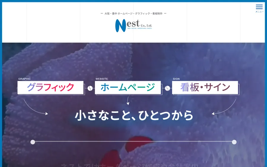 有限会社ネストのトップページ。上部に「大阪・豊中 ホームページ・グラフィック・看板制作」の一文とNest Co.,Ltd.のロゴ。写真の上に「グラフィック」「ホームページ」「看板・サイン」の3つの箱が矢印でつながり、中央に「小さなこと、ひとつから」の見出し